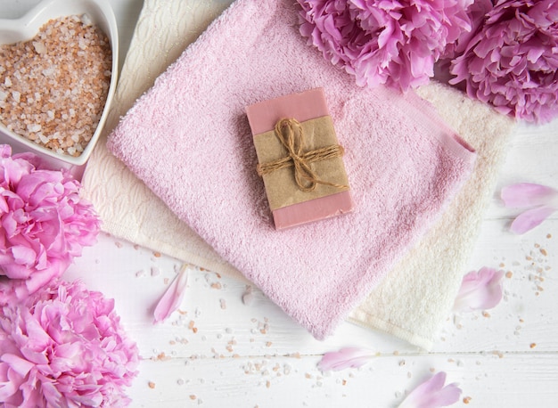 Bars of handmade soap,  soft towels and peony flowers