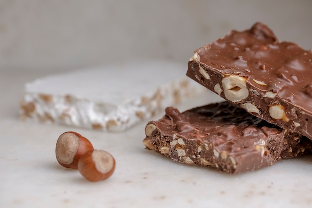 Foto bars van zoete chocolade nougat met walnoten op een witte tafel