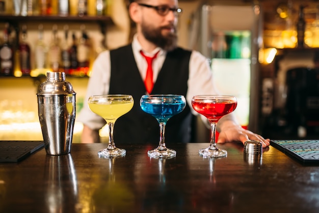 Bartender behind bar counter show alcohol coctails