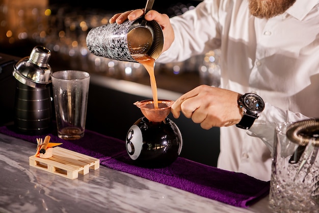 Bartender bartender is pouring a drink. Alcoholic drink