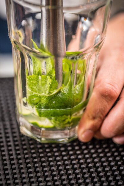 Bartender crushes mint and lime
