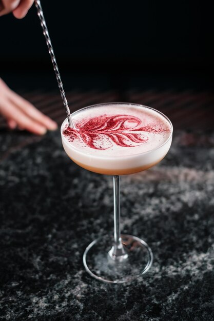 Bartender draws on a cocktail preparing drinks in a bar