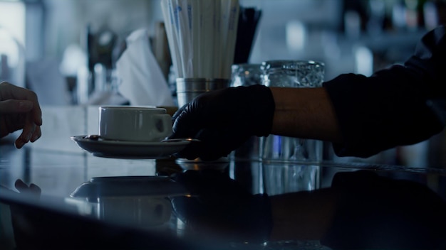 Bartender hands giving espresso cup to client closeup Barista serving hot drink