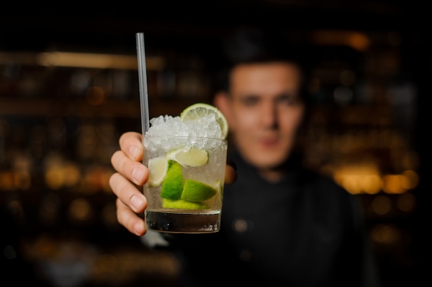 Bartender holding a glass with a fresh mojito