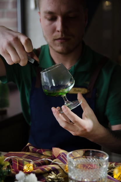 the bartender ignites a cocktail flame from a green cocktail