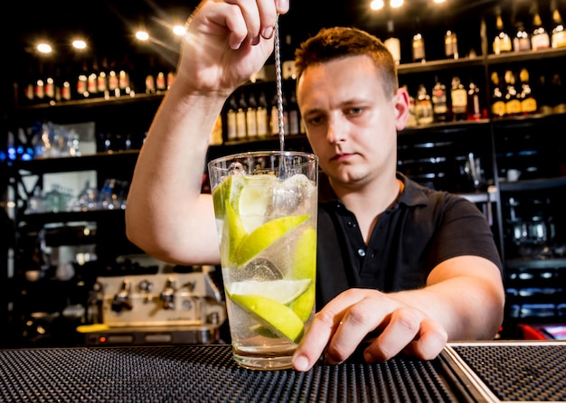 Photo bartender is making cocktail at bar counter. fresh cocktails. barman at work.