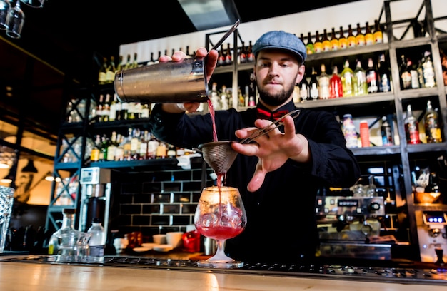 Il barista sta preparando un cocktail al bancone del bar. cocktail freschi.