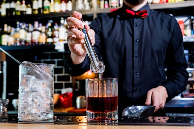 Il barista sta preparando un cocktail al bancone del bar. cocktail freschi.