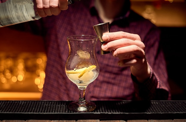 The bartender is preparing an alcoholic cocktail