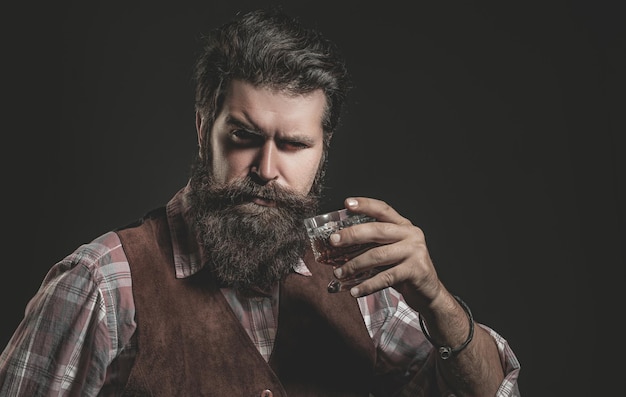 Bartender leather apron holding whisky cocktail in glass Old traditional whiskey drink gentlemen beverage