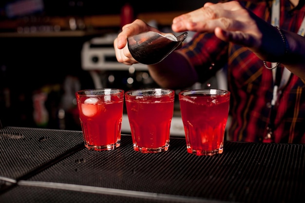 A bartender make at the bar makes a cocktail with alcohol in a bar. The concept of nightlife.