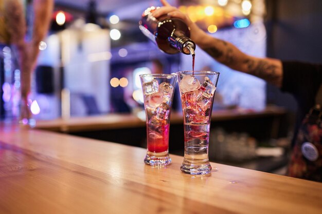 Foto il barista prepara un cocktail luminoso e delizioso sul bancone del bar