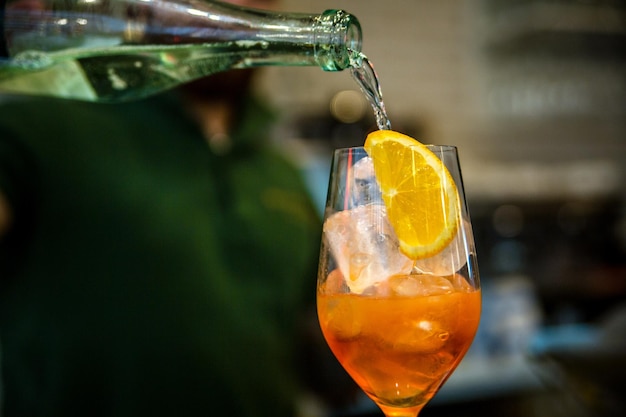 The bartender makes a cocktail Pouring alcohol from a bottle