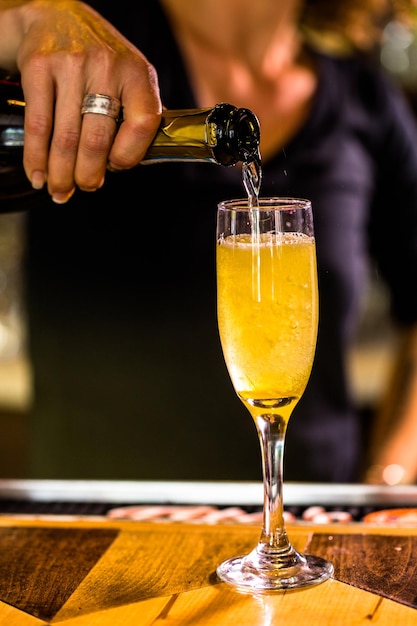 Bartender making Bellini cocktail in Italian restaurant.