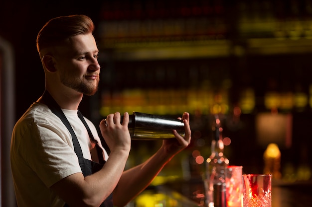 barman using shaker for cocktail preparation. Portrait of barman making  tequila based margarita Stock Photo by stockcentral