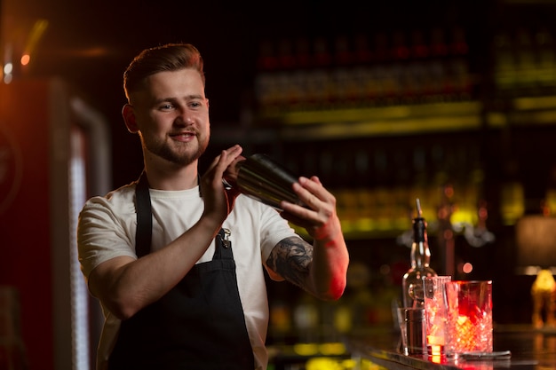 Foto barista che prepara un cocktail con uno shaker