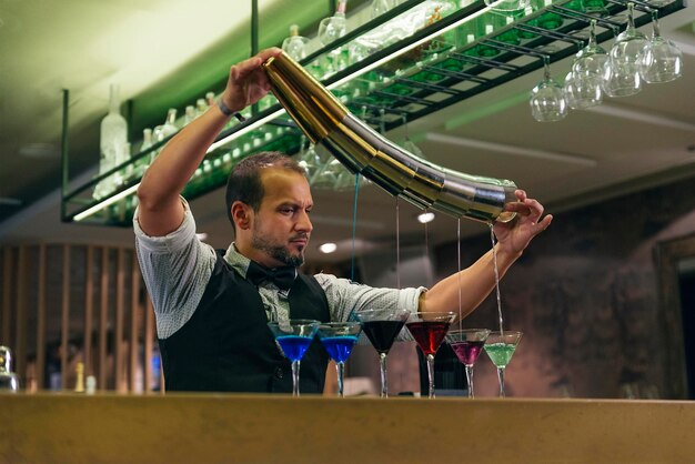 Фото Бармен делает напитки на прилавке в баре