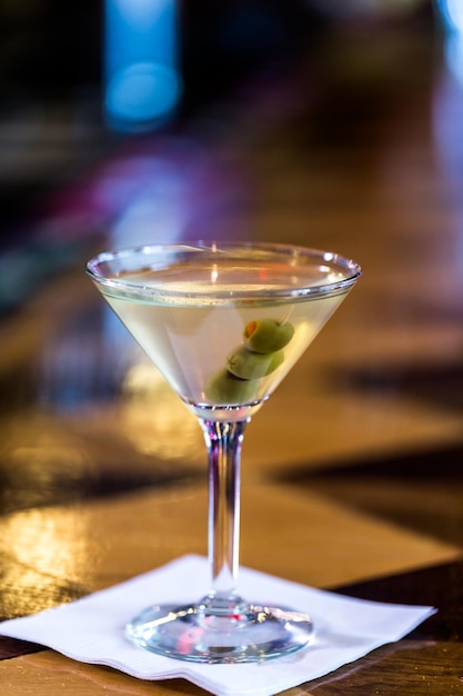 Bartender making martini with olives in Italian restaurant.