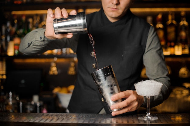 Bartender mixing drinks for making a cocktail