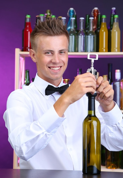 Bartender opens bottle of wine