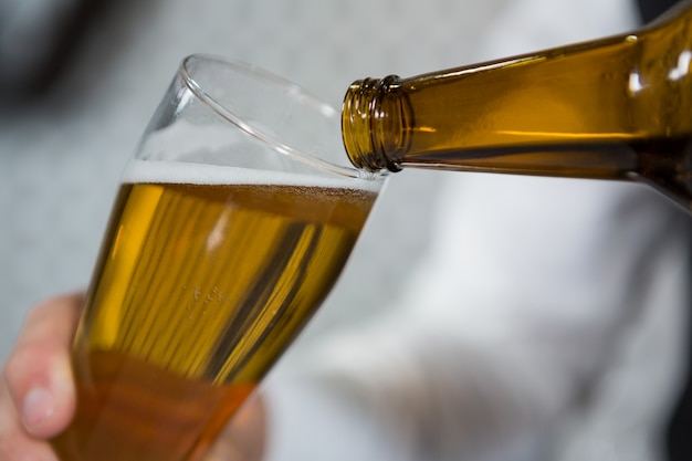 Bartender pouring beer in glass