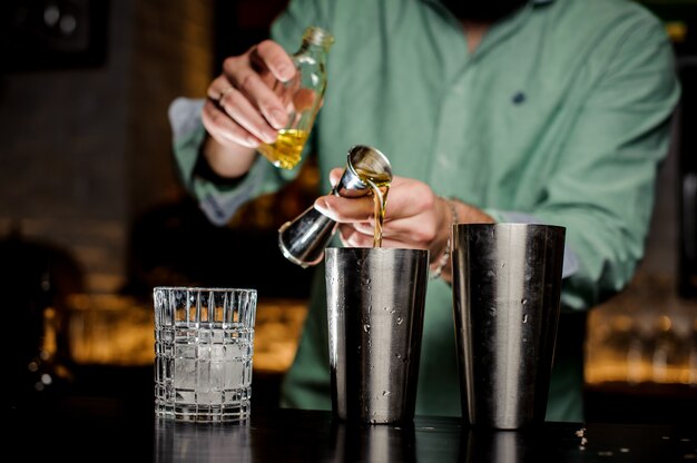 The bartender pours alcohol in a bar