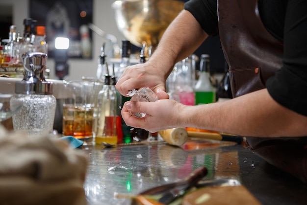 Bartender pours alcoholic drink into small glasses with flames