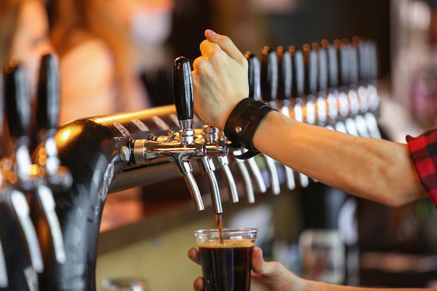 the bartender pours beer in the beer bar