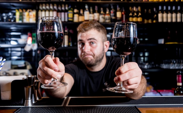 バーテンダーは赤ワインをグラスに注ぎます。ソムリエ。飲食店。ナイトライフ