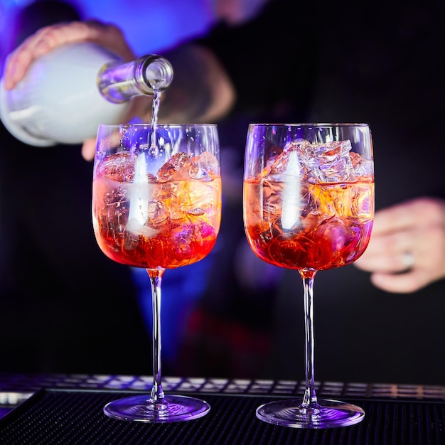 Bartender prepares alcoholic cocktail on bar counter