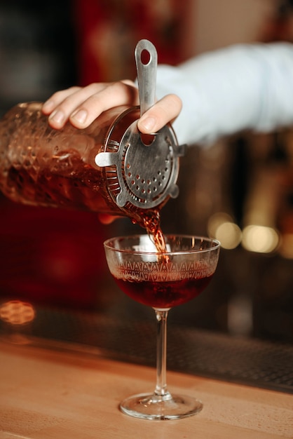 Photo the bartender prepares a cocktail for the client at the bar counter