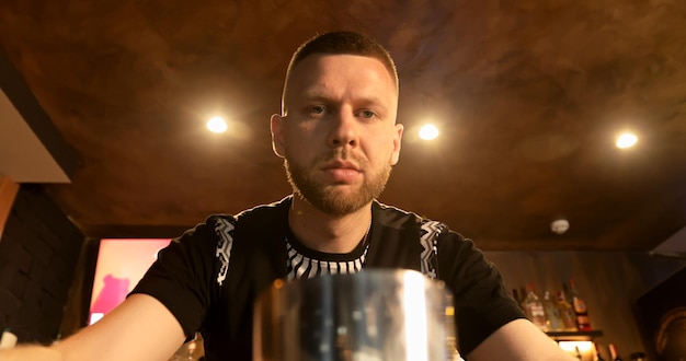 The bartender prepares a delicious cocktail at the bar. The barman adds raw eggs to the drink and throws it away.