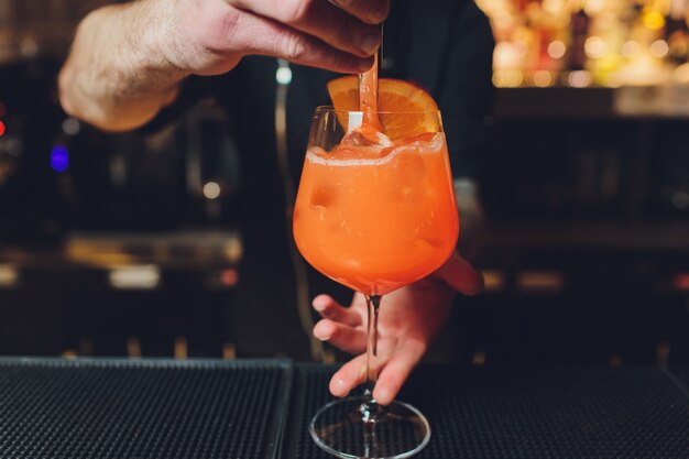 Barista che prepara aperitivo alcolico, aperol spritz cocktail.