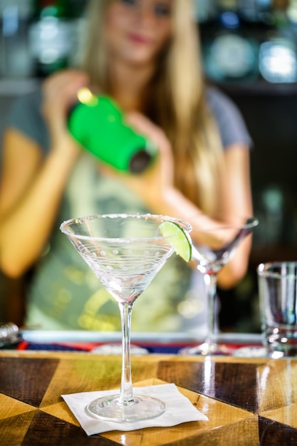 Bartender preparing Cosmopolitan drink for customer.