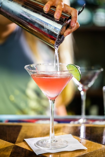 Bartender preparing Cosmopolitan drink for customer.