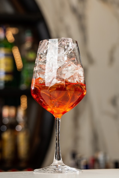 カウンターで準備するバーテンダーAperolSpritzクラシックでさわやかなイタリアの食前酒がミキシングされました