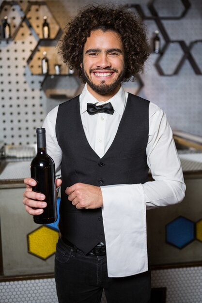 Bartender serving bottle of wine in bar counter