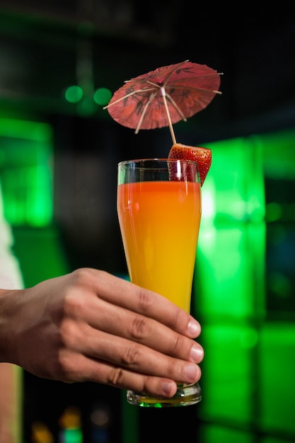 Bartender serving a glass of cocktail in bar