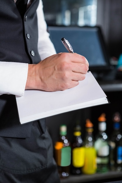 Bartender writing down an order in a bar