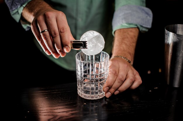 Бармен концепция ручной резки ледяной шар в баре