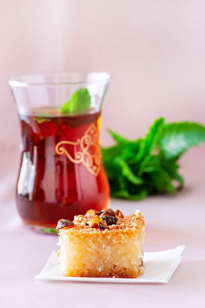 Basbousa or Namoora traditional arabic dessert and mint tea. Delicious homemade semolina cake. Copy spase. Selective focus.