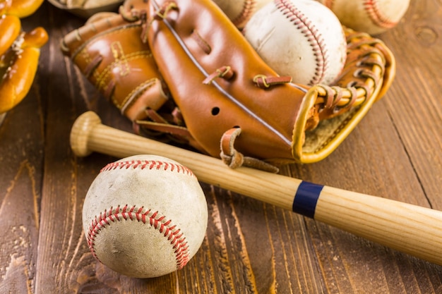 Baseball ball and glove on a wood board.