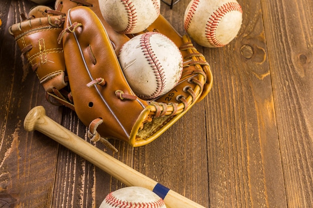 Baseball ball and glove on a wood board.