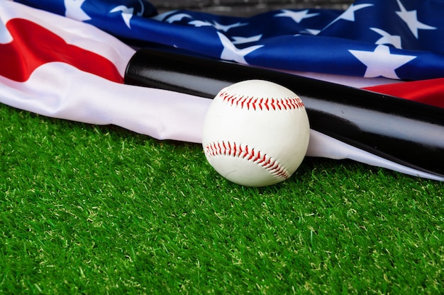 Photo baseball bat and ball with american flag on grass