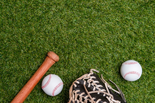 Photo baseball bat, glove and ball on green grass field