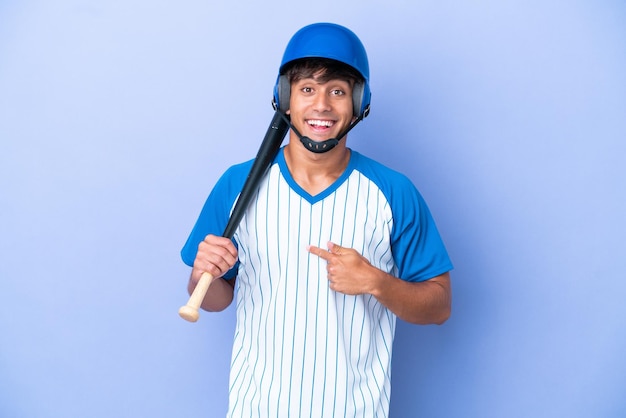 Baseball caucasian man player with helmet and bat isolated on blue background with surprise facial expression