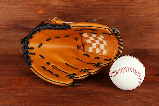 Baseball glove and ball on wooden background