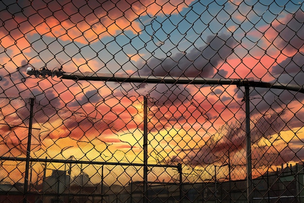 Baseball net with sunset sky and clouds vintage filter effect