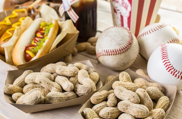 Cibo per feste di baseball con palline e guanti su un tavolo di legno.