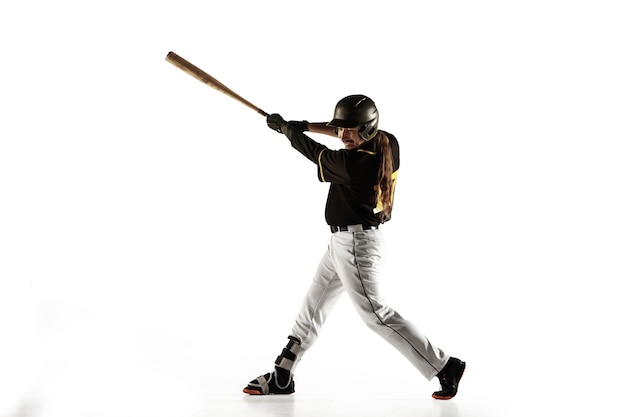 Baseball player, pitcher in a black uniform practicing and training isolated on a white wall. Young professional sportsman in action and motion. Healthy lifestyle, sport, movement concept.